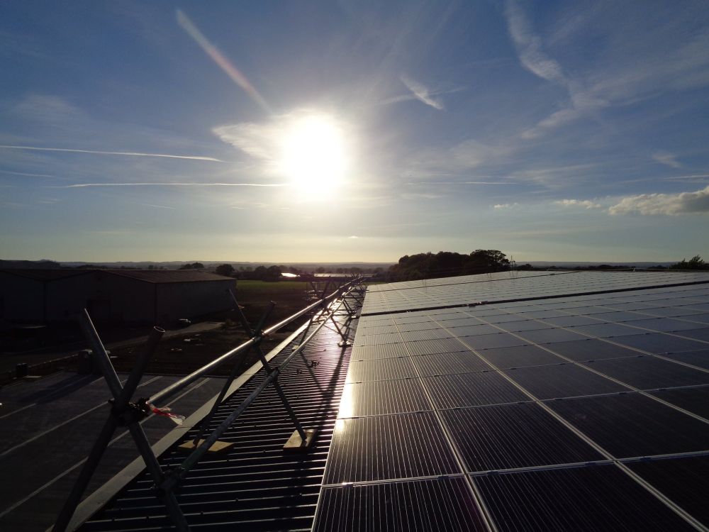 Commercial solar panels fitted to a trapezoidal metal factory roof